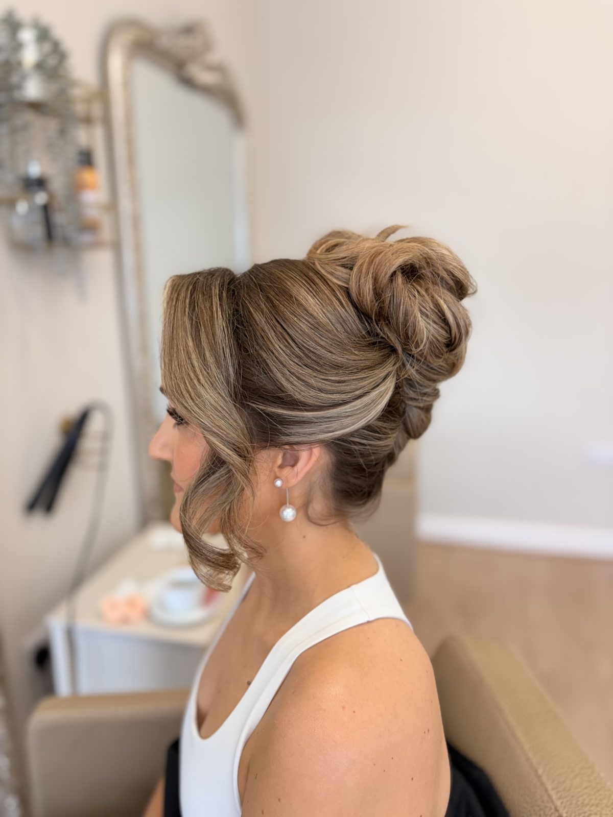 Textured high bun with soft face-framing pieces, side view