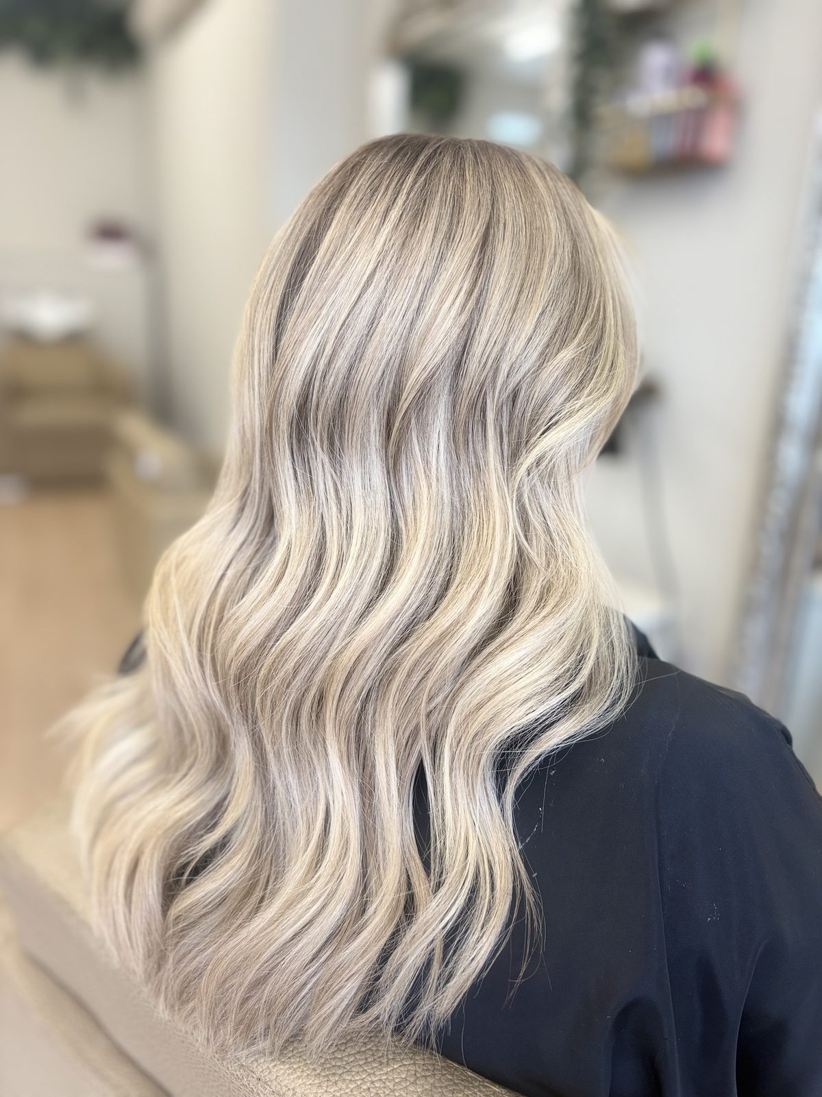 Long icy blonde hair in loose waves, seen from behind