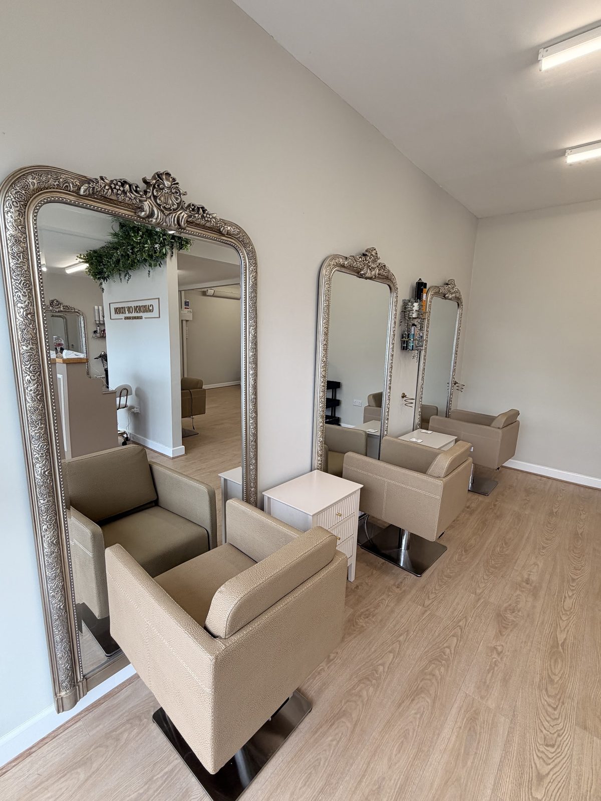 The styling floor with ornate silver mirrors and taupe chairs
